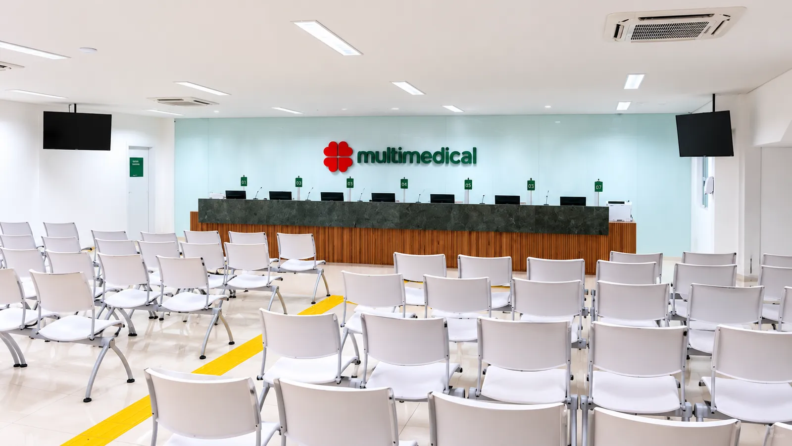 Recepção da Multimedical, no Alecrim, em Natal, com o logo da clínica no balcão de atendimento
